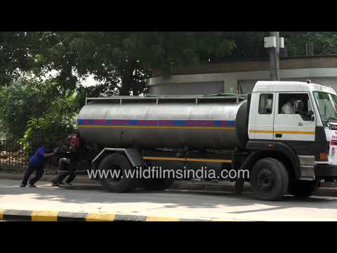 NDMC water tanker crew works beside the road near Pragati Maidan in Delhi