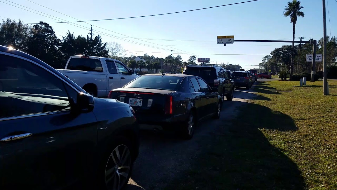 newspaper Parents wait on U.S Highway 98 to pick up children from Florosa Elementary