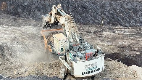 Action of a liebherr R 9350 Excavator loading overburden into a Caterpillar 777 dumper 