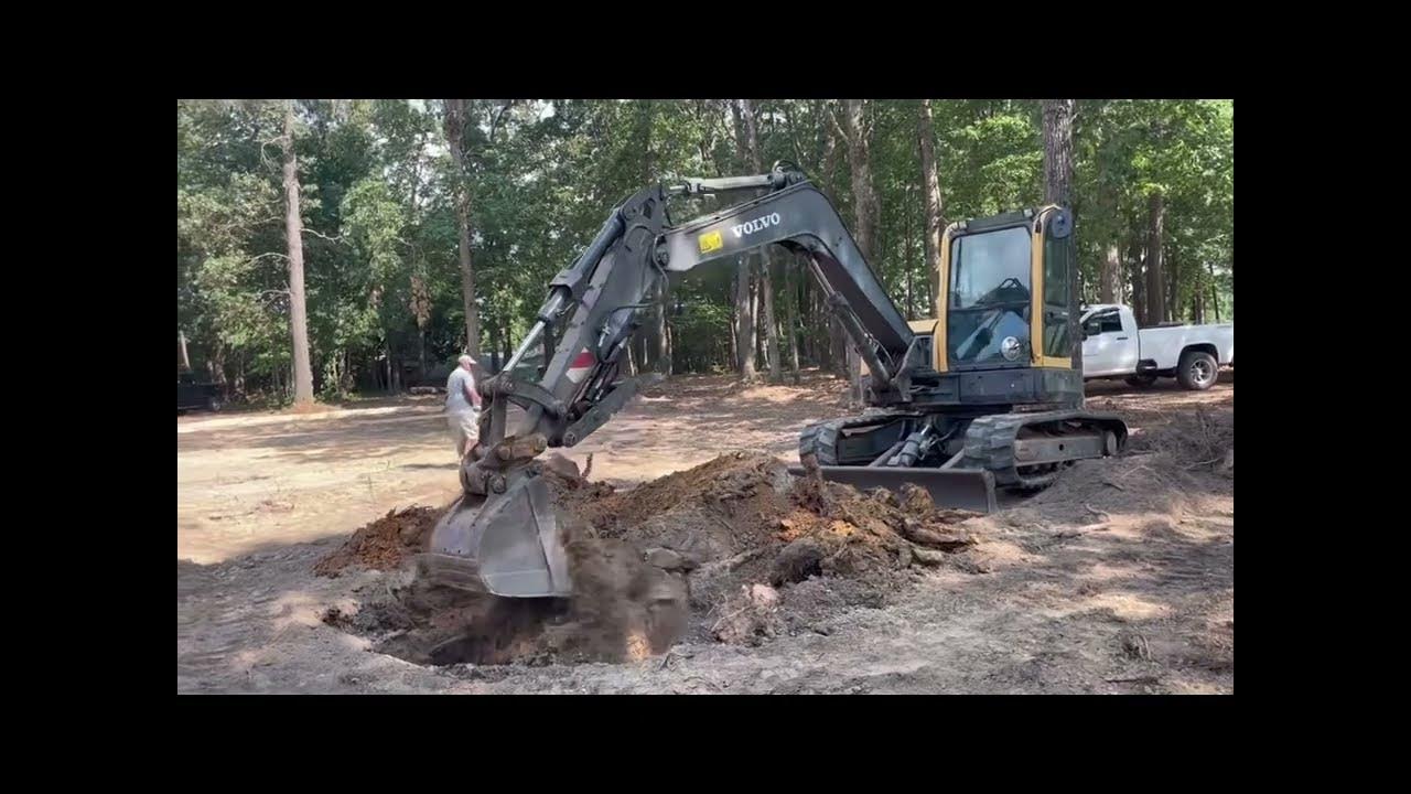 Digging stumps out of lawn with Volvo ECR88 excavator to allow for sprinkler system & sod