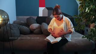 Pregnant Woman With Bare Belly Is Reading The Book Aloud And Closing It