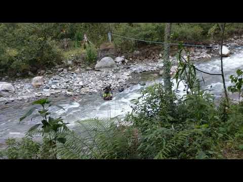 man crossing Santa Teresa River on cable