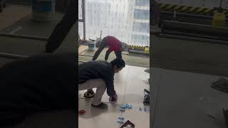 the process of installing large ceramic tiles on the upper floor of a multi-storey building #shorts