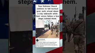 Two National Guard soldiers in full tactical gear walk ahead down a city sidewalk #shorts