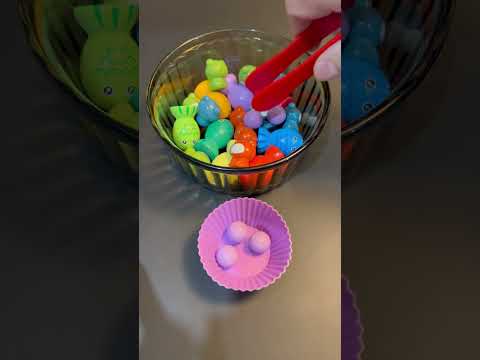 Pick out pink wooden marbles using tongs from bowl