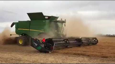 John Deere S680 and MacDon FD145 flex draper harvesting lentils