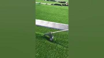 How do I treat the seams when installing artificial grass?