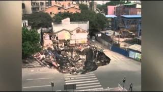 Raw: Giant sinkhole gobbles up building in China