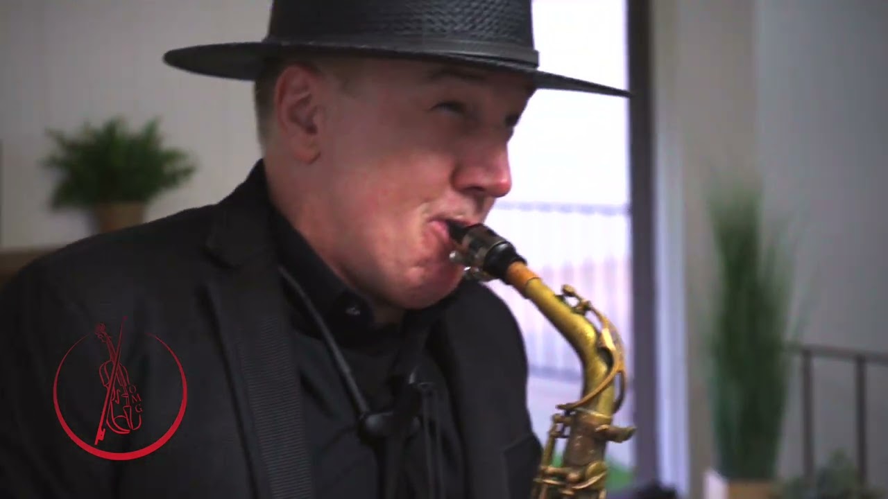 CJ performing Tragos De Amargo on saxophone