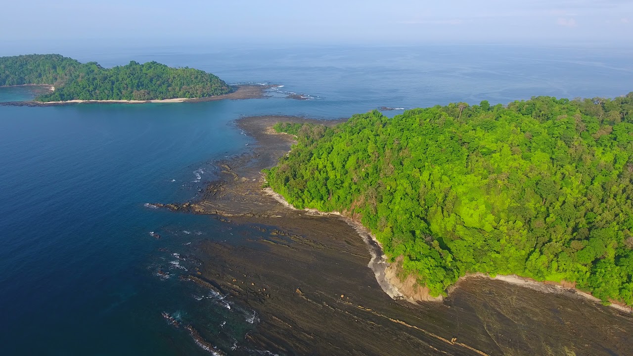 Hover Aerial of Jicaron Island Water Edge with Slate Rock Cliff Shore