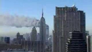 Wide shot - from midtown - towers burn. Empire State...