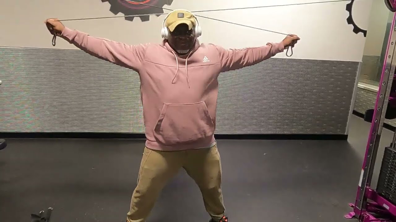 Train back with cable machine at Planet Fitness. Old man working out for life until nature stop him