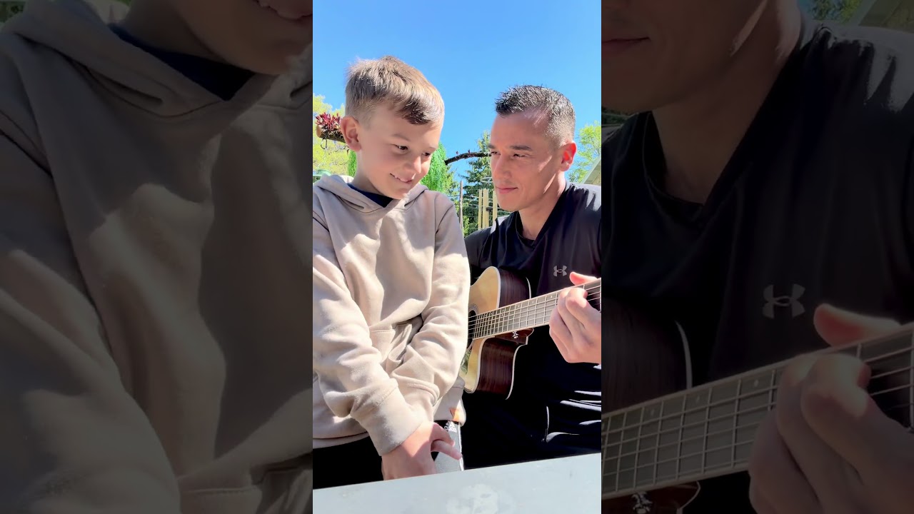 Father playing song for son on the guitar