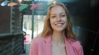 Good-looking young blonde standing with serious face then smiling laughing in city