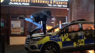 Protester Slips On Burned-Out Bonnet Of Police Car In Bristol During 'Kill The Bill' Riot