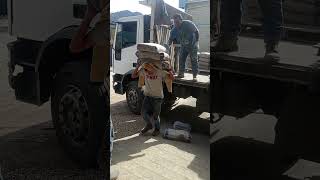 Worker Stumbles and Falls While Carrying Cement Bags Into Warehouse