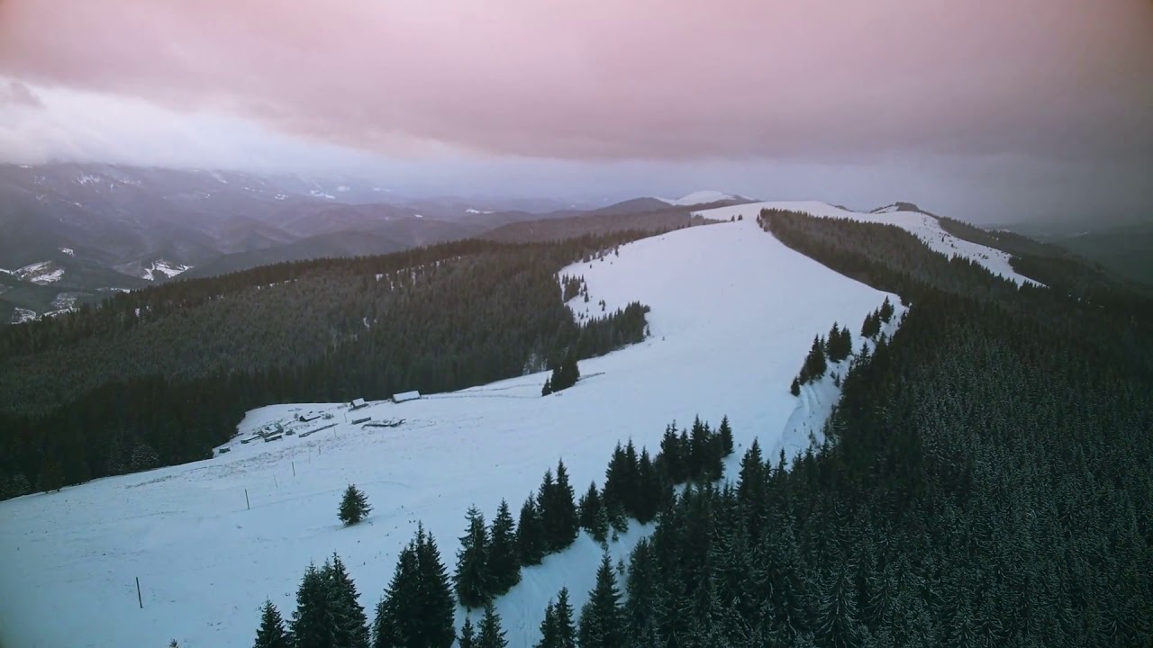 aerial drone view flight over winter mountains sunset time ski