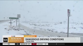 Dangerous driving conditions as snow falls in Cajon Pass