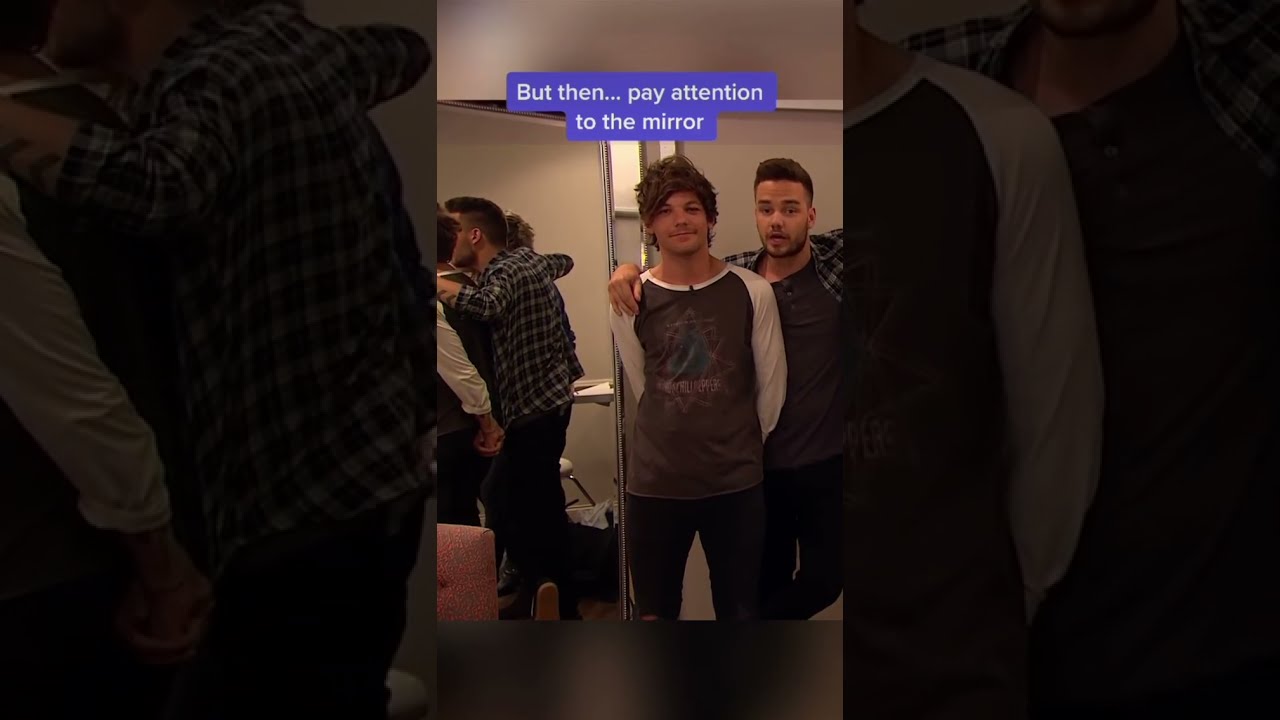 Louis Tomlinson teasing Liam Payne and pulling on his shirt while they read it holds his hand