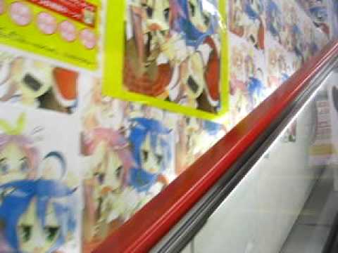 Suzumiya Haruhi & Lucky Star dance on an escalator in Akihabara