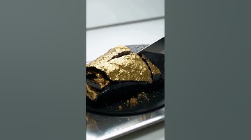 Golden obsidian shaped like a taco sliced cleanly in half