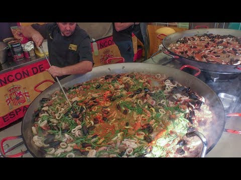 Many Huge Pans Cooking Spanish Paella. Street Food Fair in Italy