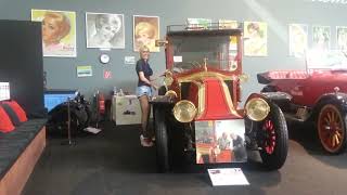 Granate styling, Walking through classic car Museum, micro shorts, fishnet stockings visible, wedges