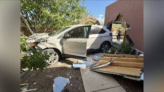 Driver hospitalized after crashing through wall in east Tucson