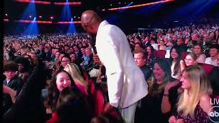 Celebrity Wayne Brady sits on Jonathan Mangum at The AMA’s 2022 Net Worth