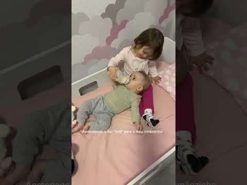Alice aprendendo a dar mamadeira para o Vitor