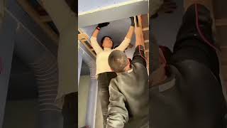 the process of installing flexible boards on a wooden ceiling frame in a hallway of a building room