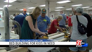 Volunteers help build beds for kids