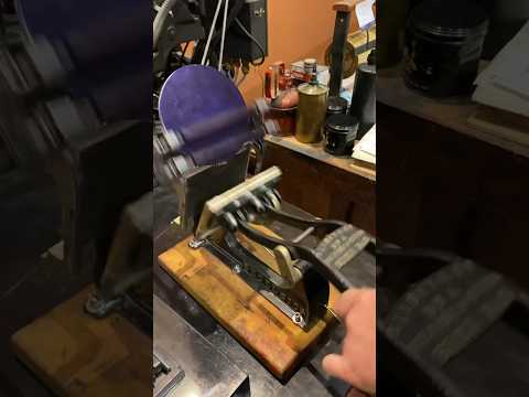 Using a tabletop printing press to print a blue picture of a printing press