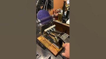 Using a tabletop printing press to print a blue picture of a printing press
