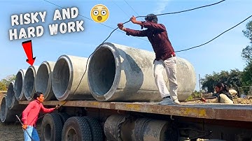 Unloading huge and heavy cement pipes from truck