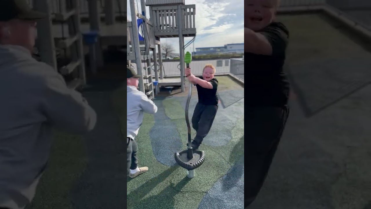 Boy stands on spinning ride at playground then falls and lands on elbow
