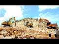 Hardworking doosan komatsu caterpillar with hydraulic breaker smashing limestone