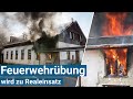 Feuerwehrbung wird zu realeinsatz kamerad von flammen eingeschlossen