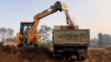 A JCB Loading Soil In A Remote Village And A Tripper Busy Carrying Soil
