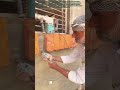 Maçonnerie verticale en briques sur le mur extérieur d'un bâtiment, sous une grille de fenêtre