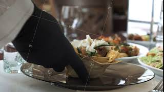 The waiter puts greek salad in a basket of pita bread on a plate, close-up