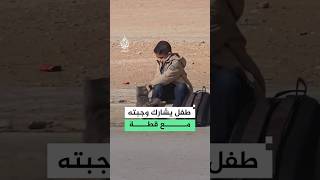 Algerian boy shares his school meal with a stray cat