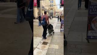 Ирусалим, Израиль. ￼Семья с маленькими детьми на прогулке. Отец с коляской и М16