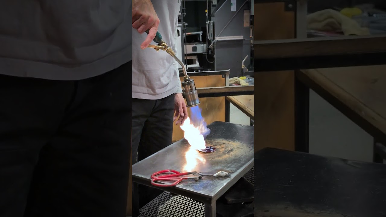 Pressing hot glass into a custom mold.  🏅we never get tired of watching a medallion come together🔥