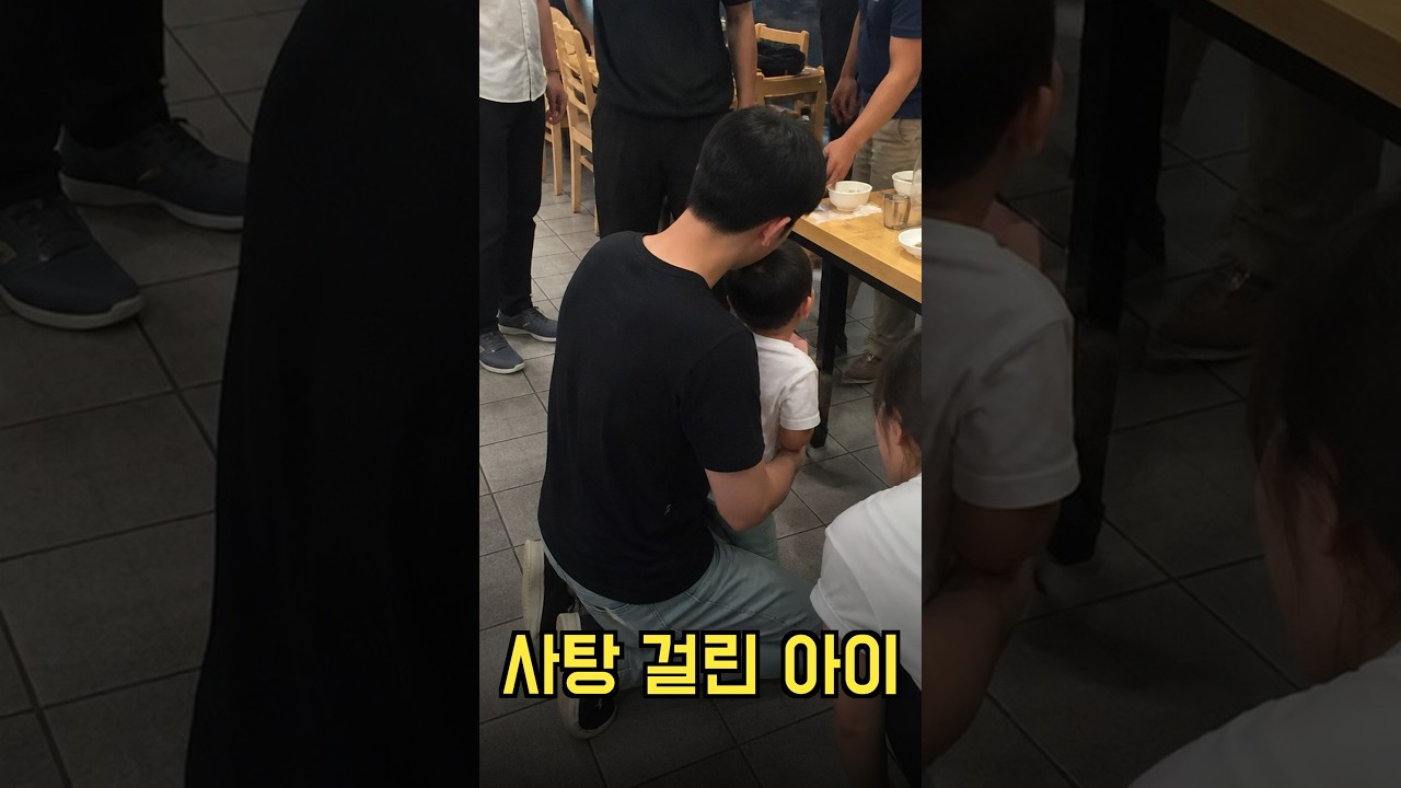 사탕이 목에 걸려 얼굴 파래진 아이를 뒤에서 감싸 안은 남성