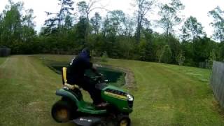 Taking a chance mowing a steep slope around  Pond With Rider