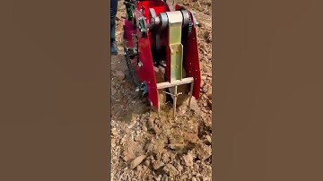 The machine works to dig through soil using a wide heavy spatula designed for strong ground tasks
