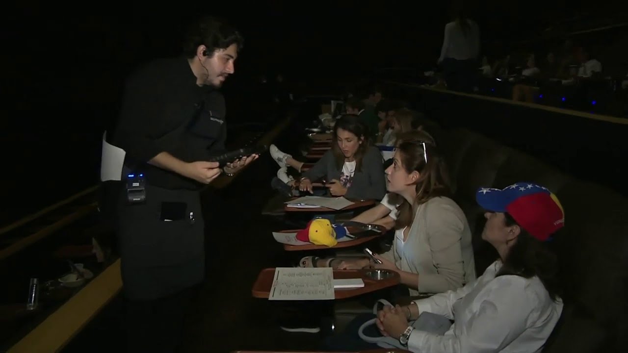 Venezuelan migrants watch Venezuela Aid Live concert from downtown Miami theater