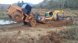 pa carregadeira puxando escavadeira do barro com força máxima