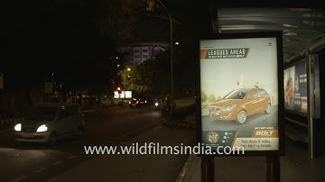 Fast moving traffic near Lodhi Colony bus stand at night, New Delhi